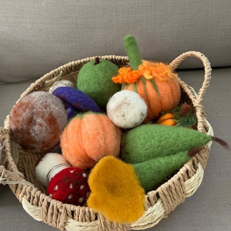 A basket of felted pumpkins, mushrooms and apples