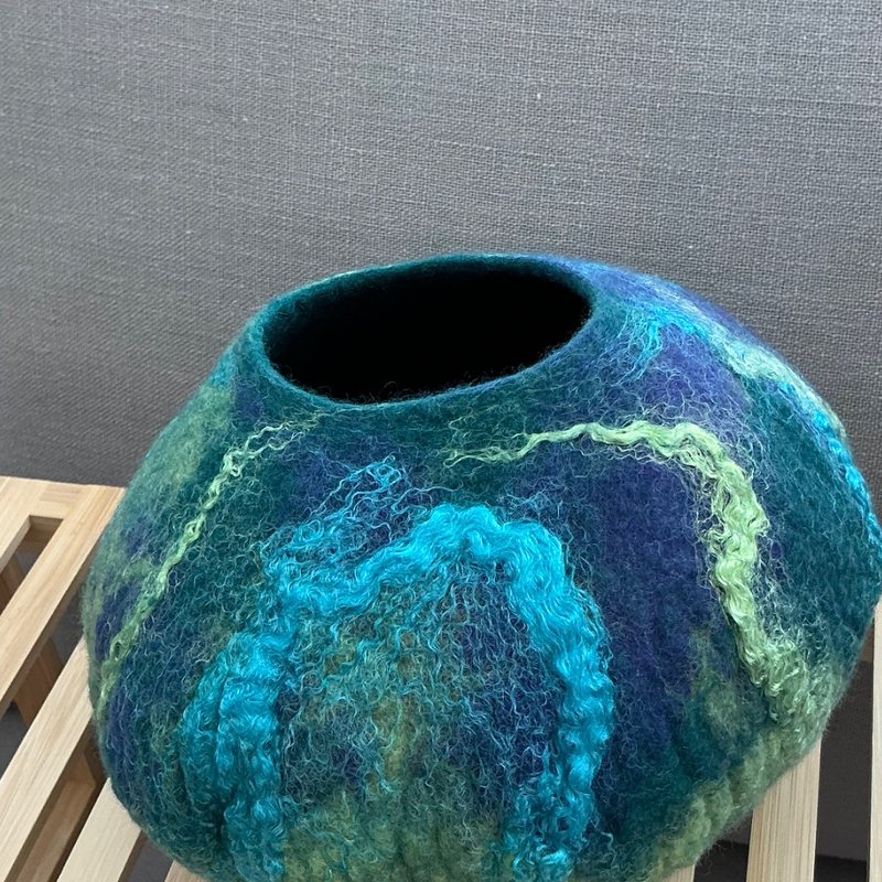 A wet-felted teal and green vessel