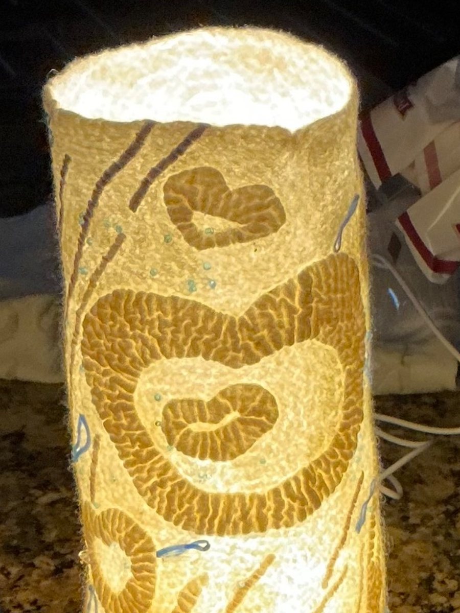 A wet-felted lantern glowing from inside, with cut-work and stitched motifs